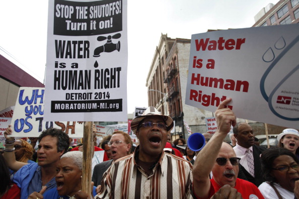 Group of Protesters march with signs against mass water shutoffs in Detroit, Michigan on July 18, 2014.